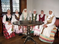 Anykščių giesmininkės (iš kairės) Danutė Janušytė-Karčemarskienė, Aldona Dulkienė, Violeta Juciuvienė, Rita Urbonienė, Vitalija Meškauskienė ir Vijoleta Vanagienė A. Baranausko namuose Kaune prie autentiško stalelio.