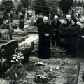Anykštėnai prie rašytojos kapo. Meldžiasi monsinjoras Albertas Talačka. Apie 1994 m.